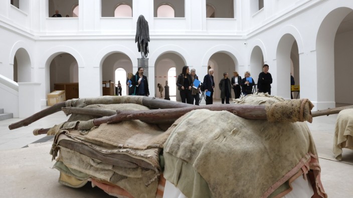 Diözesanmuseum Freising: Die Betten-Installation im Foyer des Museums aus Textilien, Wachs und Holz steht für die Verletzlichkeit des Menschen, im Hintergrund der "Arcangelo".