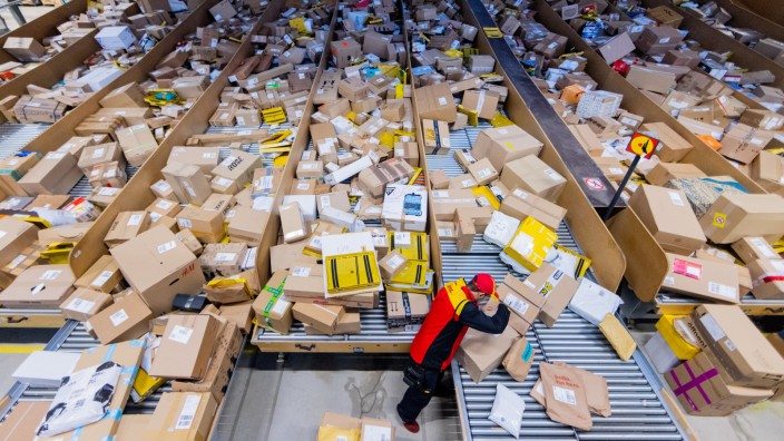 Logistik: Ein DHL-Mitarbeiter sortiert in einer Zustellbasis der Deutschen Post Pakete.