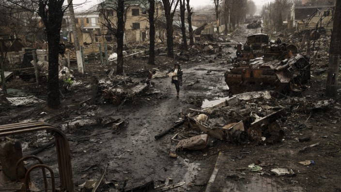 Journalismus: Eine Frau geht inmitten zerstörter russischer Panzer in Butscha. Das Bild ist Teil einer Serie von Bildern von Fotografen der Associated Press, die 2023 mit dem Pulitzer-Preis für Nachrichtenfotografie ausgezeichnet wurde.