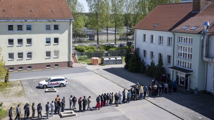 Flüchtlingsgipfel: Migranten stehen in einer Schlange in einer Erstaufnahmeeinrichtung in Brandenburg.