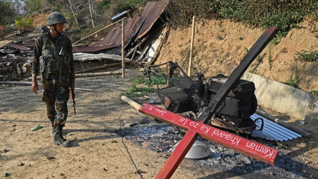Ethnischer Konflikt: Ein indischer Soldat sichert einen Ort im Bezirk Senapati, wo in dem Konflikt zwischen Kuki und Meitei Häuser und eine Kirche niedergebrannt wurden.