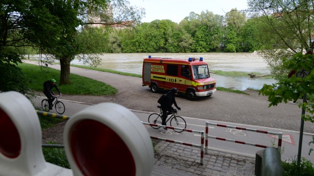 Regenwetter in München: Noch ist der Radweg in der Nähe der Reichenbachbrücke nicht überschwemmt, doch das Wasser kommt gefährlich nahe. Die offiziell ausgerufene Sperrung des Weges scheint an dieser Stelle noch nicht vollzogen zu sein, auch wenn Absperrungen bereit stehen.