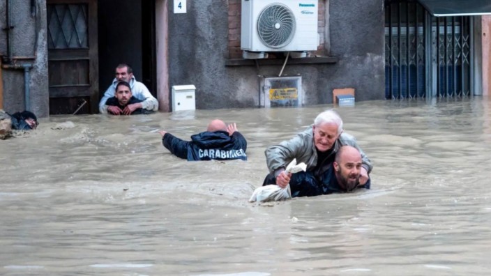 Italien: Carabinieri tragen in Faenza Anwohner huckepack durch die überschwemmten Straßen.