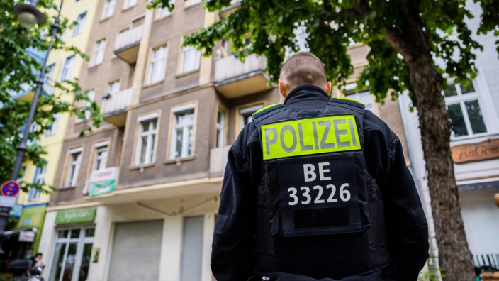 "Letzte Generation": Ein Polizist steht in Berlin-Kreuzberg bei Ermittlungen gegen Mitglieder der "Letzten Generation" vor einem Haus.