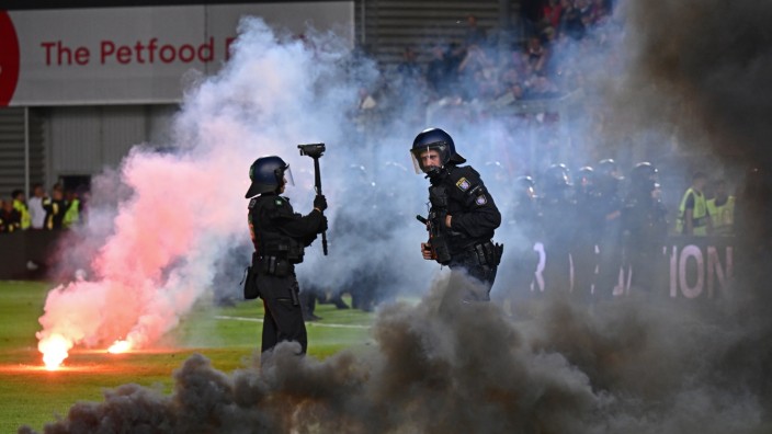 0:4-Niederlage in der Relegation: Unschöne Szenen: Polizisten räumen Feuerwerkskörper vom Fußballrasen in Wiesbaden.