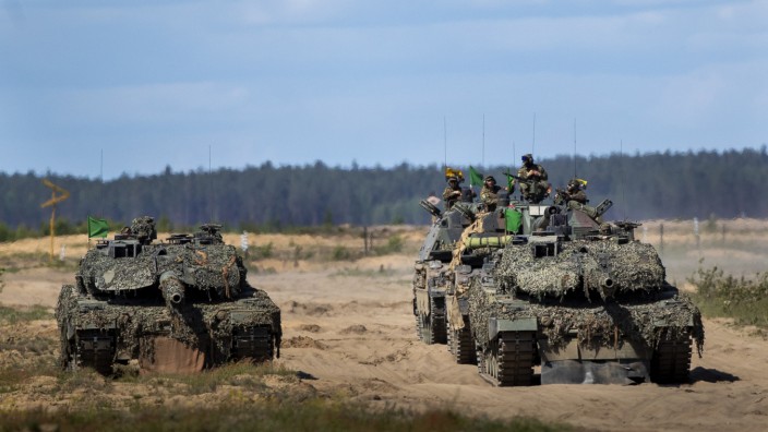 Außenpolitische Ansichten in Europa: Deutsche "Leopard 2"-Panzer (vorne) und "Panzerhaubitzen 2000" mit aufsitzenden Soldaten in Litauen.