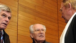 Der Angeklagte Roland K. mit seinen Verteidigern beim Prozessauftakt in Traunstein, dpa