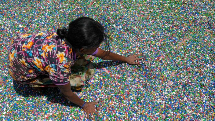 Umwelt: Eine nachhaltige Lösung? Eine Arbeiterin inmitten von Plastikchips aus alten Flaschen in einer Recycling-Fabrik in Sri Lanka.