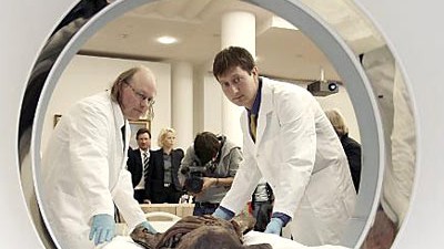 Archäologie: Frank Rühli und der Mannheimer Kurator Wilfried Rosendahl schieben eine Mumie in einen Kernspintomographen.