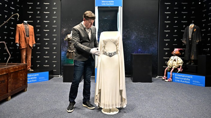 Versteigerung in Hollywood: Mit weißen Handschuhen wagt sich der Auktionator an das Kleid der Prinzessin Leia.