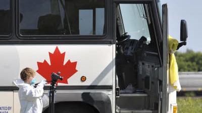 Kanada: Ein Polizist fotografiert den Bus, in dem ein Mann einen anderen Fahrgast enthauptet haben soll