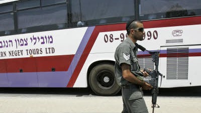 Rettung im Westjordanland: Ein israelischer Sicherheitsbeamter patrouilliert neben einem Bus mit Fatah-Anhängern, die vor der Hamas geflüchtet sind.