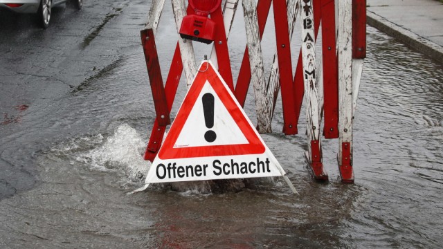 Unwetter: Am Samstagmorgen warnt ein Verkehrsschild Autofahrer auf einer überfluteten Straße bei Viktring im Süden von Klagenfurt.