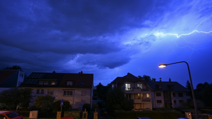 Gewitter: Blitze entladen sich am Abendhimmel während eines schweren Gewitters über Häusern in Frankfurt.