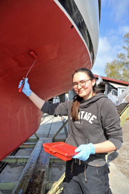 Historisches Segelboot: Franzi Gattinger hat die Leidenschaft für Schiffe von ihrem Vater: Sie (hier bei letzten Lackarbeiten an der Lady Shackleton 2022) absolviert mittlerweile eine Ausbildung zur Bootsbauerin.