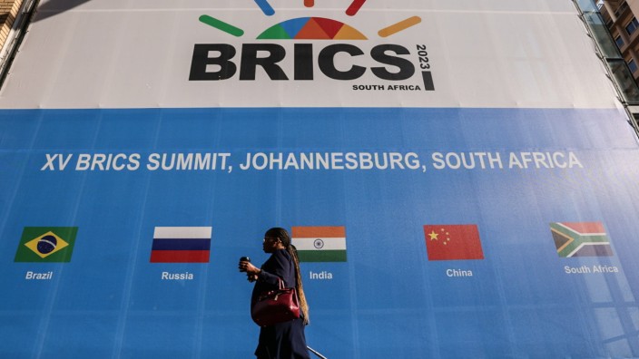 Gipfel in Südafrika: Das Brics-Treffen bringt Chancen und Risiken für den afrikanischen Gastgeber: Eine Frau vor der Gipfelwerbung in Johannesburg.