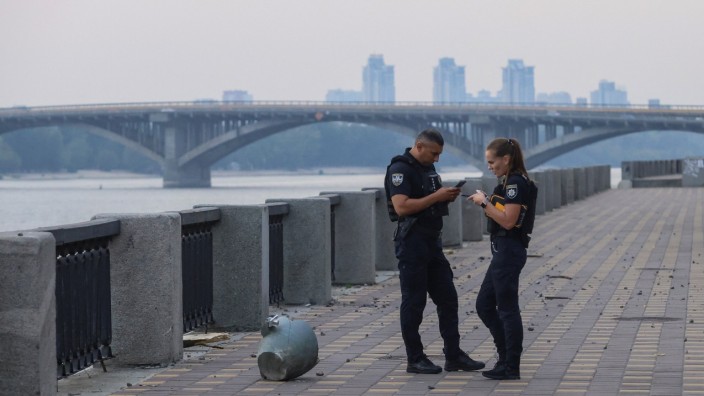 Krieg in der Ukraine: Ukrainische Polizisten sichern Teile einer russischen Rakete, die am Mittwoch an einer Uferpromenade am Dnipro in Kiew einschlug.