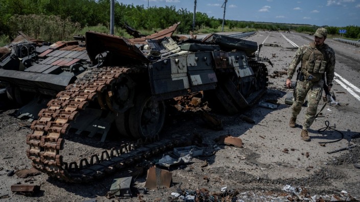 Krieg in der Ukraine: Ein ukrainischer Soldat geht in Robotyne an einem zerstörten ukrainischen Panzer vorbei.