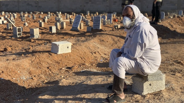 Wetterextreme: Tage der Trauer in Darna: Ein Mann sitzt neben Gräbern von Opfern der Sturzflut.