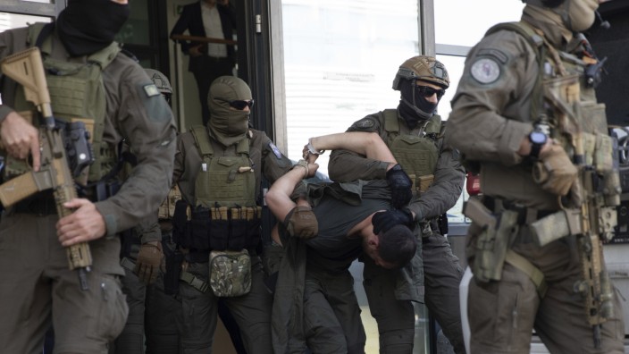 Balkan: Polizisten einer kosovarischen Spezialeinheit eskortieren einen der festgenommenen serbischen Angreifer aus dem Gerichtssaal.