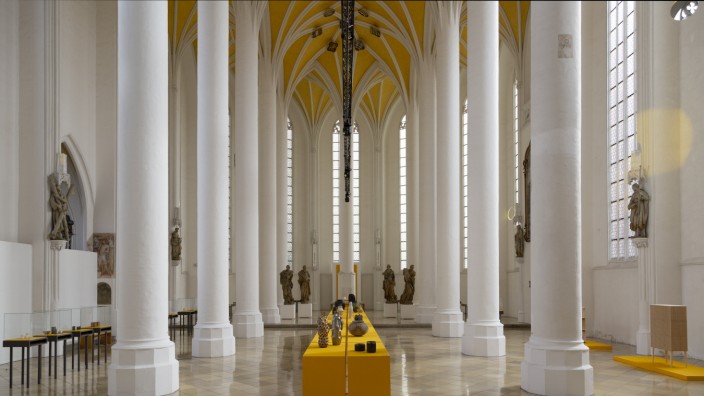 Danner-Preis 2023: Dottergelb wie der Grund des Rippengewölbes in der Heilig-Geist-Kirche in Landshut leuchtet der Laufsteg, auf dem die Objekte des diesjährigen Danner-Preises ausgestellt werden.