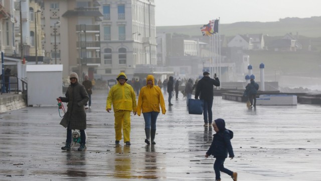 Sturm in Frankreich: Mensch im Regen beim Orkantief Ciaràn