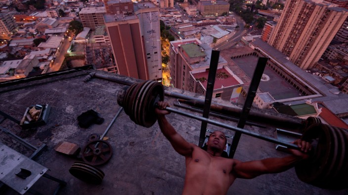 "Iwan Baan - Momente der Architektur": Bodybuilder auf dem Dach des Torre David, einem nie fertiggestellten und inzwischen zum vertikalen Slum gewordenen Wolkenkratzer in Caracas, 2011.