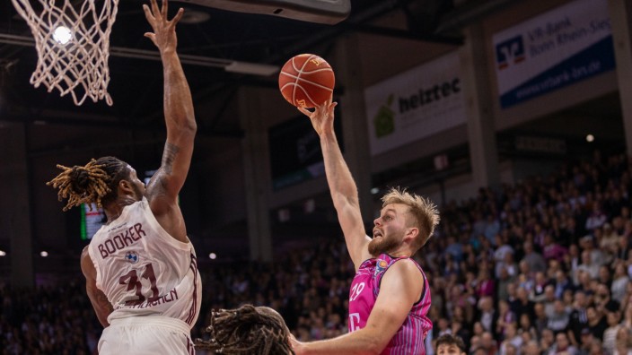 Basketball: Zu hoher Luftstand für die Bayern um Devin Booker (links): Bonns Till Pape freut sich mit den Telekom Baskets über den Sieg nach Verlängerung.