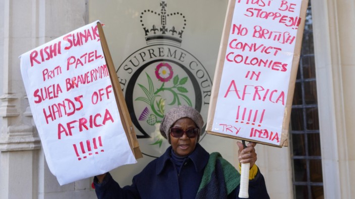 Großbritannien: "Hände Weg von Afrika": Eine Demonstrantin vor dem Obersten Gerichtshof in London, der am Mittwoch darüber entschied, ob die Regierung ihren umstrittenen Plan fortsetzen kann, Migranten nach Ruanda abzuschieben.