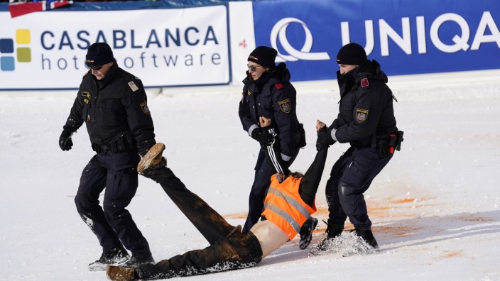 Klima-Protest beim Slalom: Ein Demonstrant wird von Polizeibeamten weggetragen.