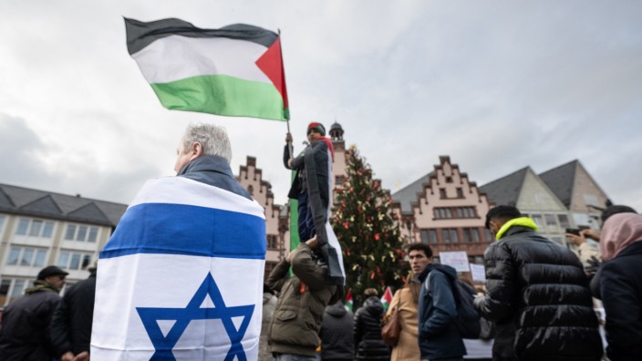 Nahost: Viel Durcheinander in Frankfurt: Ein Mann mit einer Israel-Flagge steht unter pro-palästinensischen Demonstranten bei einer Versammlung auf dem Römerberg.