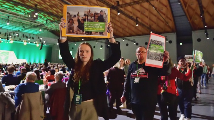 Die Grünen: Vielleicht haben sie ihren Antrag etwas unglücklich formuliert: Delegierte, die in der Parteitagshalle für eine liberale Asylpolitik demonstrieren.