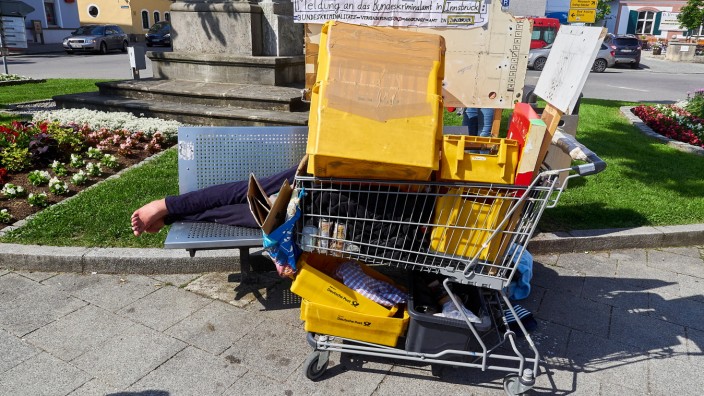 Wohnungsnot im Landkreis: Ein Obdachloser schläft mit seinen Habseligkeiten am Marktplatz in Grafing auf einer Bank. Die meisten Fälle von Wohnungsnot im Landkreis sind nicht so offensichtlich.