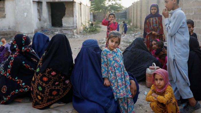 Pakistan und Afghanistan: Afghanische Frauen warten in Karachi mit ihren Kindern auf einen Bus, der sie in das Land zurückbringen soll, aus dem sie geflohen sind.
