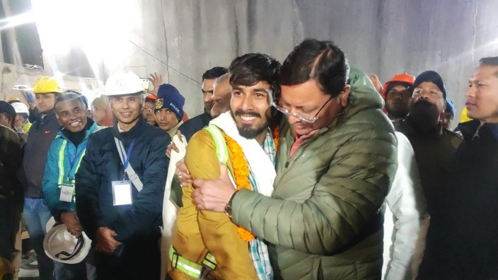 Indien: Endlich in Freiheit: Ein Politiker begrüßt einen Arbeiter, der aus dem Tunnel gerettet wurde.