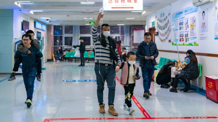 Krankheitswelle: Lange Wartezeiten, wachsende Sorgen: Ein Vater mit seinem kranken Sohn in einem Hospital in Chongqing in Südwestchina.