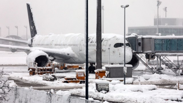 Onset of winter: A Lufthansa plane is parked at the snow-covered Munich Airport.