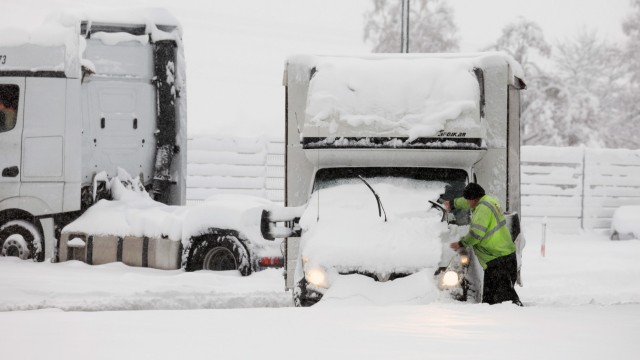 Wintereinbruch: Ein Lastwagenfahrer befreit auf einer Raststätte an der Autobahn A96 bei Landsberg am Lech sein Fahrzeug vom Schnee.