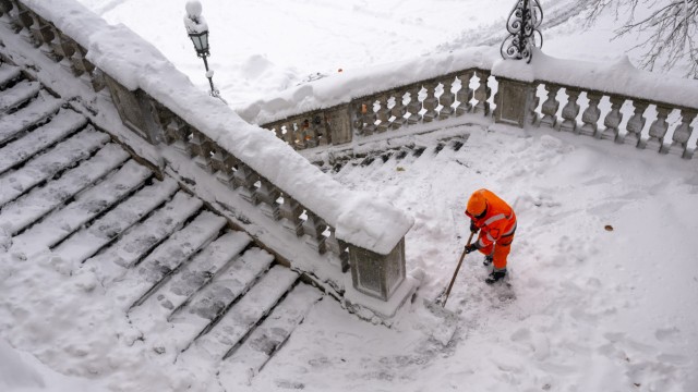 Winter in der Stadt: Am Friedensengel: Ein Mitarbeiter der Stadtreinigung räumt den Schnee von der Treppe.