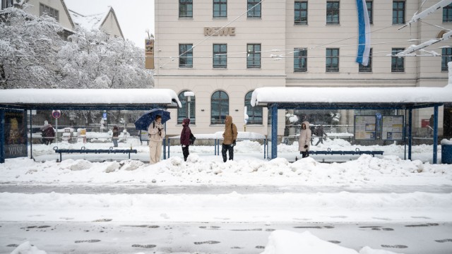 Schnee in München: Fahrgäste stehen am Hauptbahnhof an einer Straßenbahnhaltestelle. Der Betrieb wurde wegen der massiven Schneefälle eingestellt.