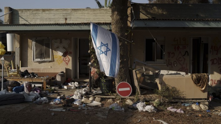 Israel nach dem 7. Oktober: Israelische Flagge vor einem zerstörten Haus im Kibbuz Kfar Azza.