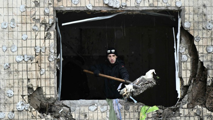 Krieg in der Ukraine: Ein Anwohner beseitigt Schutt aus einem zerstörten Gebäude in Kiew nach einem russischem Raketenbeschuss Anfang des neuen Jahres.