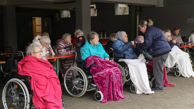 Faschingsumzüge: Eine Gruppe Seniorinnen und Senioren verfolgte das Spektakel unter einem Dach und in warme Decken gehüllt.