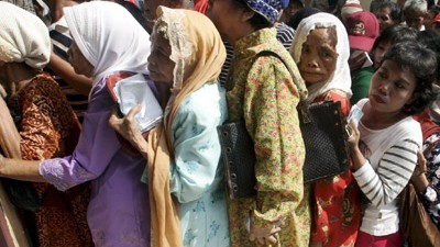 Organhandel in Indonesien: Menschen stehen vor einer Hilfsorganisation in der indonesischen Hauptstadt Jakarta um kostenlosen Reis Schlange (Archivbild). Immer mehr Indonesier suchen im Internet einen Ausweg aus der Armut - notfalls durch den Verkauf ihrer Organe.