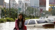 Neue Überschwemmungen in Jakarta: Land unter in Jakarta - eine Frau kämpft sich vorwärts.
