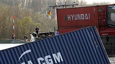 Container blockieren Rhein: Container im Rhein, dahinter das havarierte Schiff