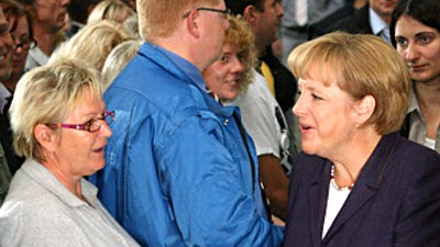Kanzlerin besucht Volkswagen: Golf-Fahrerin Merkel im Zwiegespräch mit der VW-Belegschaft.