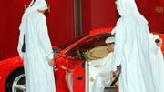 Arabische Touristen: Araber sehen sich einen Ferrari an. Die Kosten für diesen Wagen sind Nebensache.
