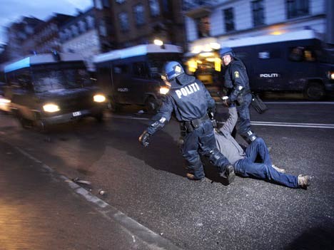 Gegen seinen Willen wird ein Demonstrant von zwei dänischen Polizisten abgeführt.