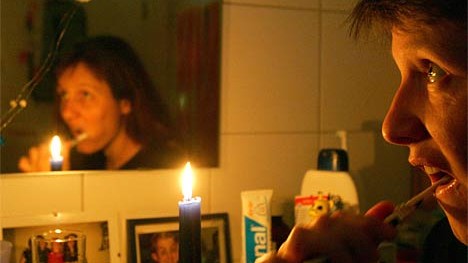 Stromausfall in Westeuropa: Eine Frau putzt sich am Sonntag in Freiburg bei Kerzenschein die Zähne - Ausnahme oder künftig häufiger der Fall?